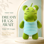 Front view of a sleepy green hippo plush toy wearing a blue-and-white striped shirt, standing on a cream-colored pedestal with a soft arched backdrop.