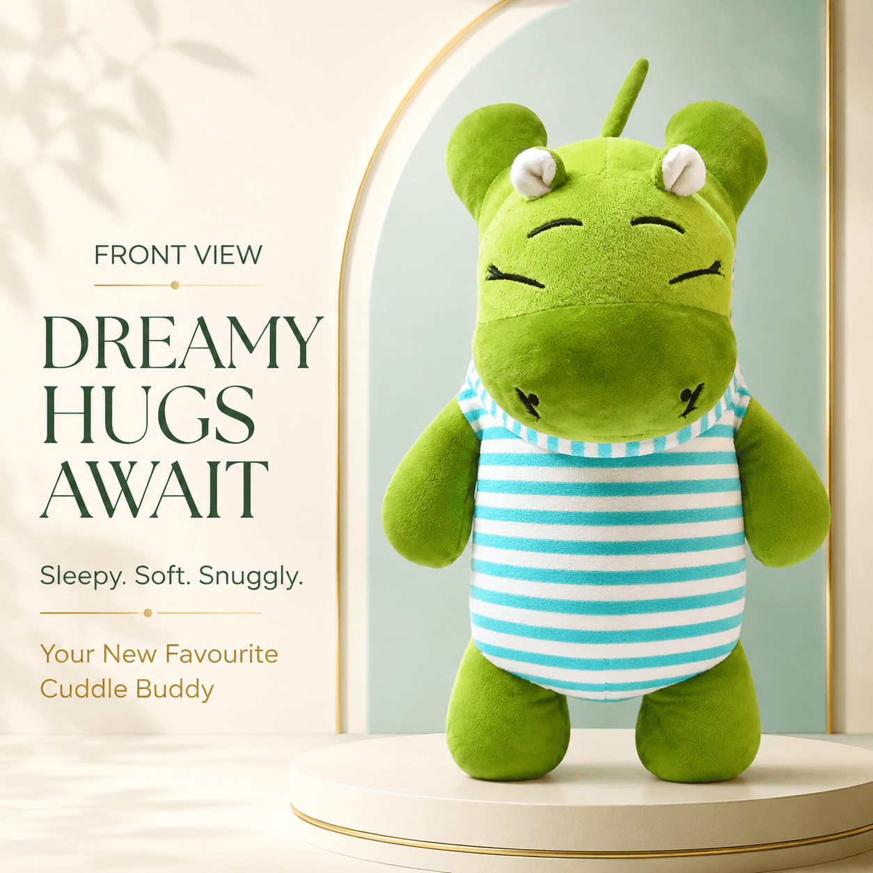 Front view of a sleepy green hippo plush toy wearing a blue-and-white striped shirt, standing on a cream-colored pedestal with a soft arched backdrop.