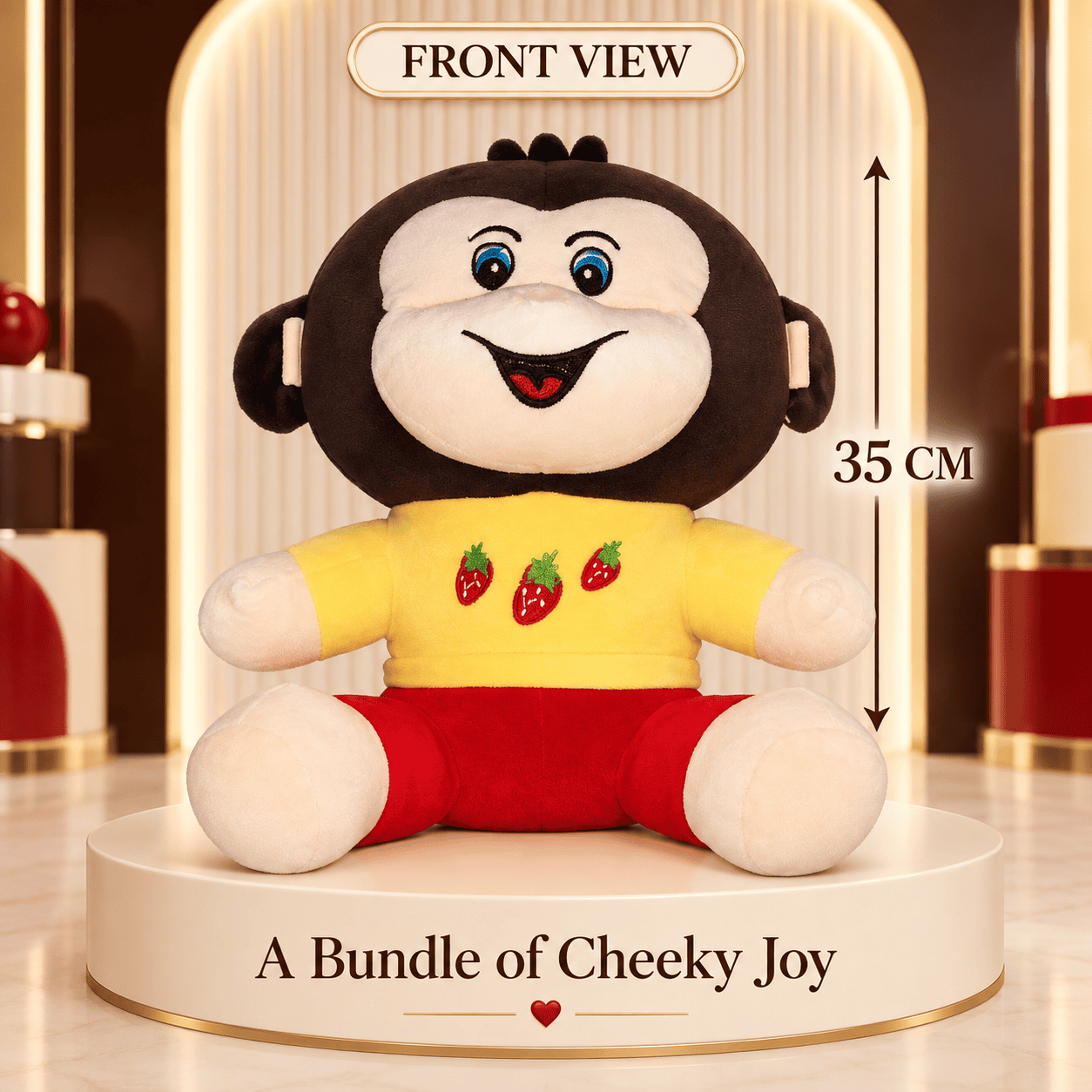 Front view of a 35cm cheeky monkey plush toy wearing a yellow strawberry top and red shorts sitting on a display platform.